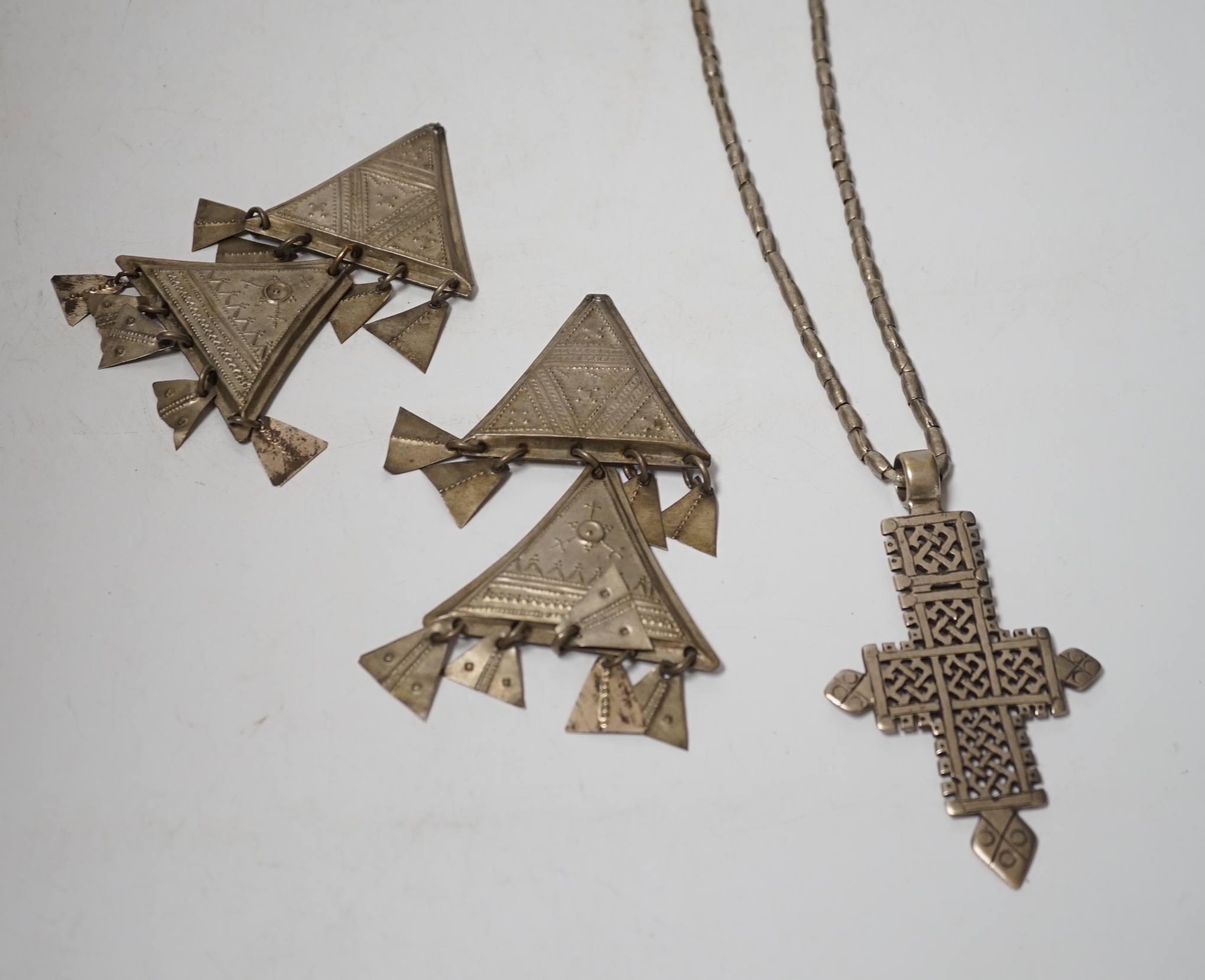 An Ethiopian white metal cross pendant necklace, overall 90cm, together with a pair of Tuareg silvered metal drop earrings (lacking hooks), approx. 12cm.